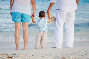 parents and baby on the beach